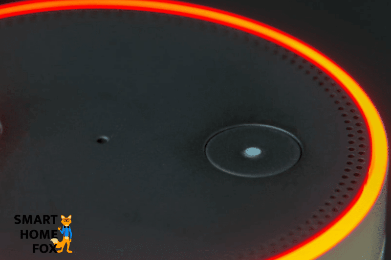 The light ring of an Amazon Echo Dot glows orange